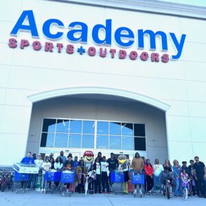 A group of people standing in front of academy sports and outdoors.