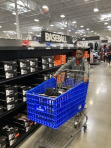 A young boy pushing a shopping cart in a store.