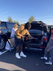 A group of people opening the trunk of a car.