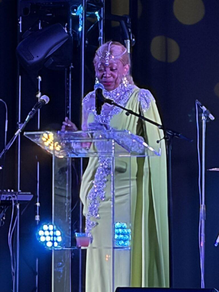 Person in green gown speaking at podium