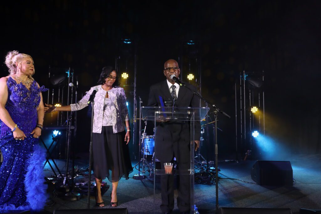 Man speaking at podium with two women