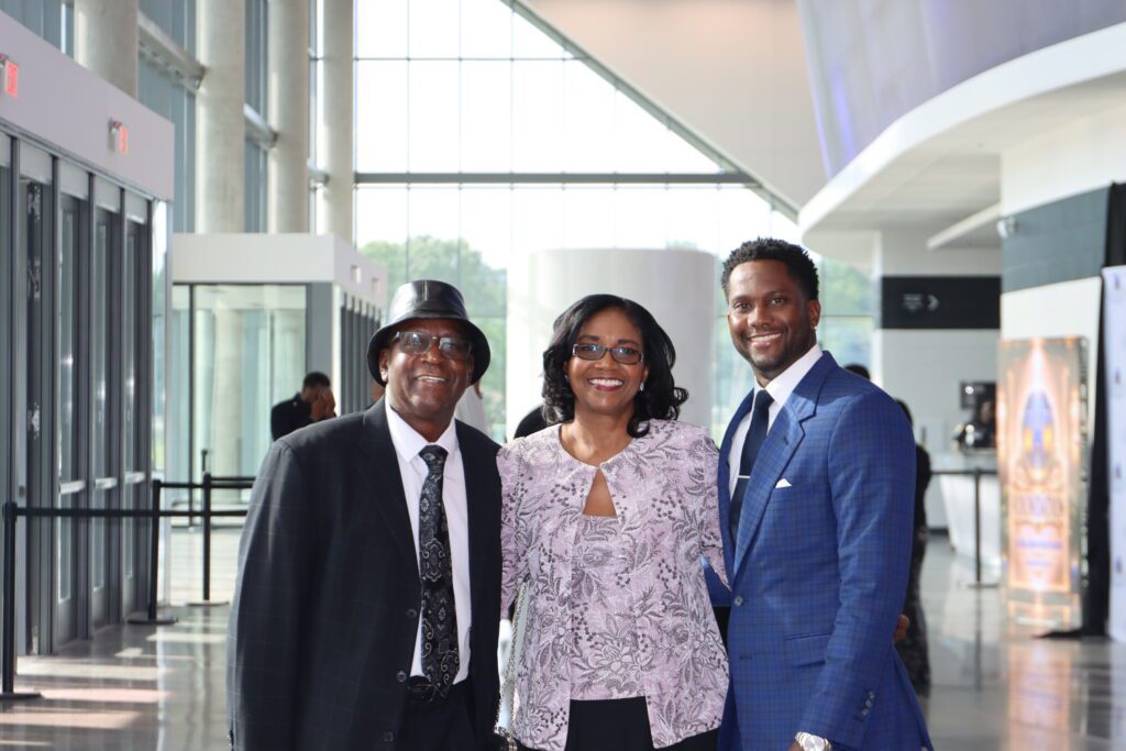 Three smiling adults dressed formally in lobby
