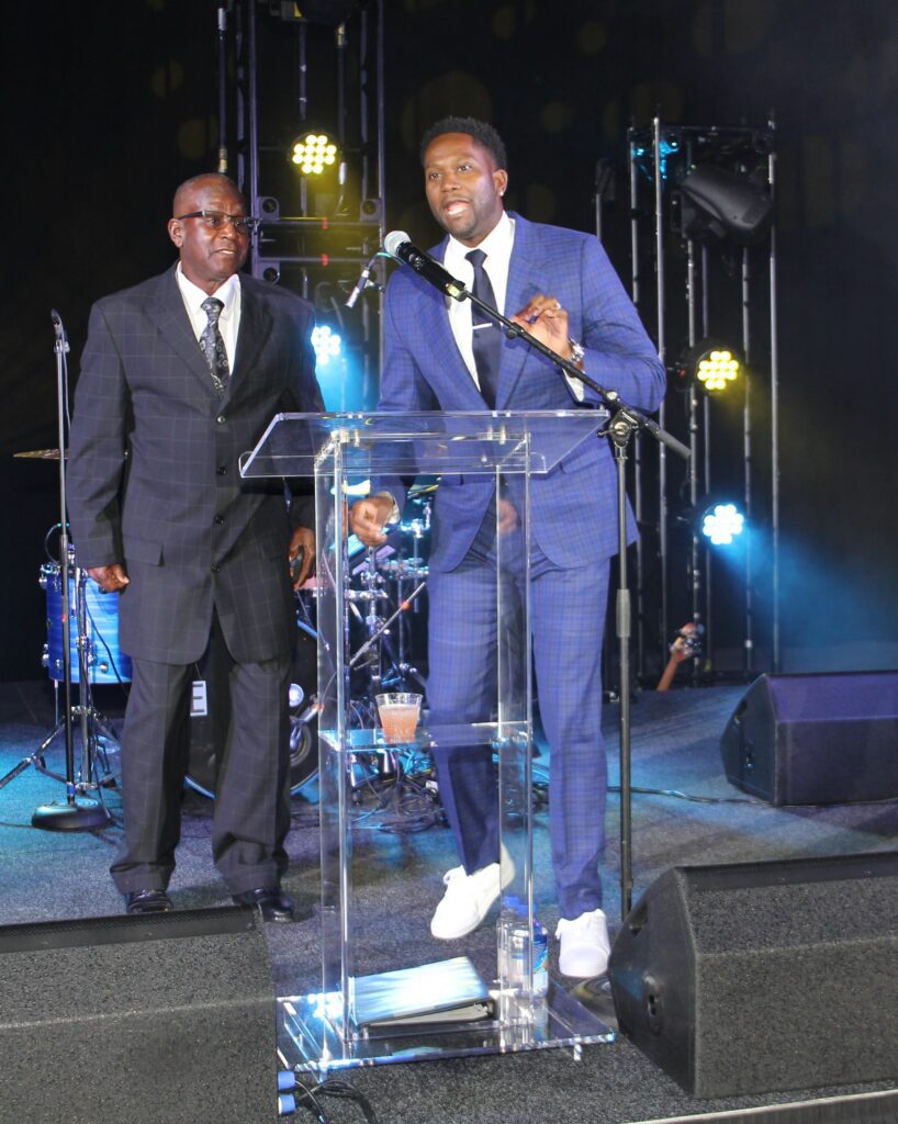 Two men in suits speaking at podium