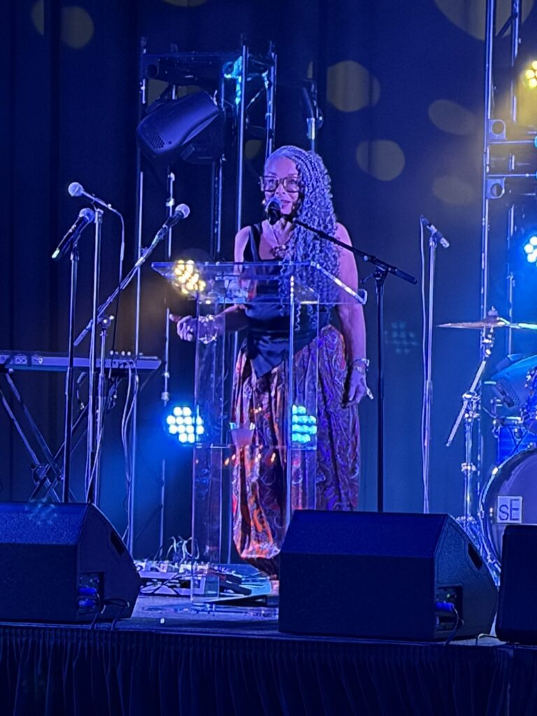 Person speaking at podium on illuminated stage