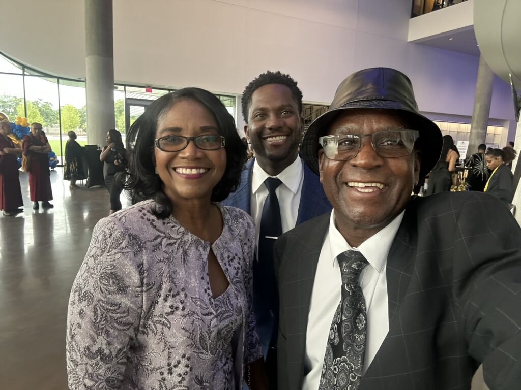 Three smiling adults at formal event